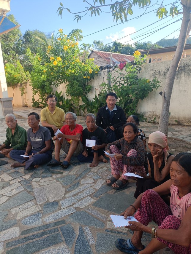 A group of people sitting on a stone surfaceDescription automatically generated