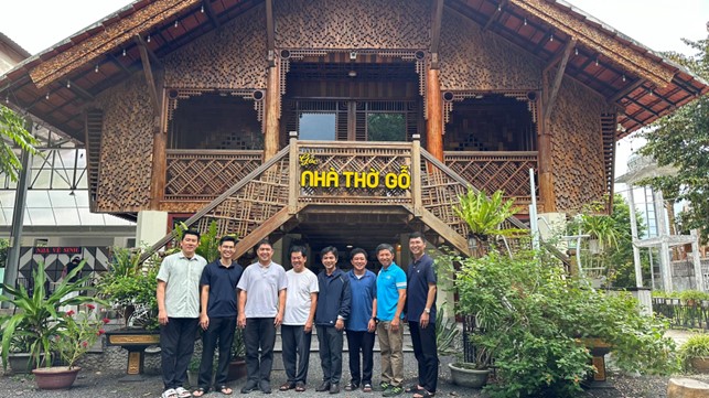 A group of men standing in front of a buildingDescription automatically generated