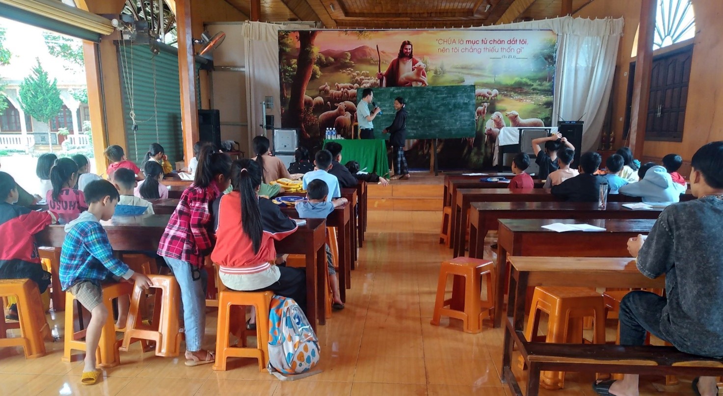 A group of people sitting at desks in a classroomDescription automatically generated