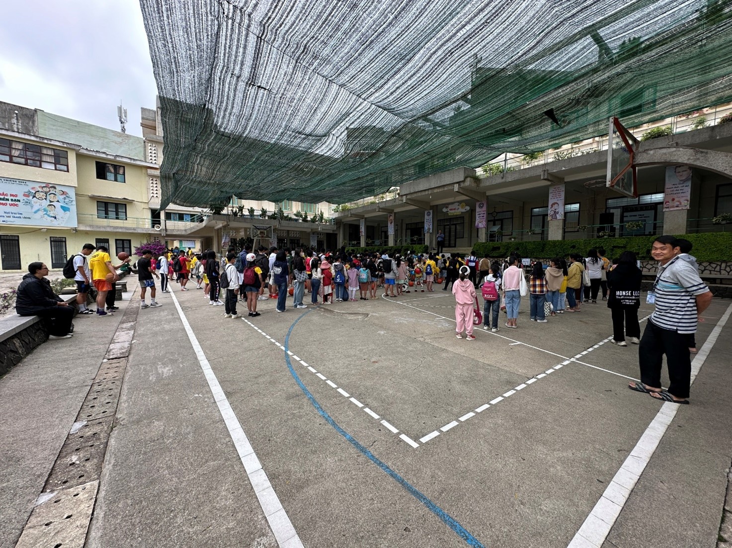 A group of people standing in a parking lotDescription automatically generated