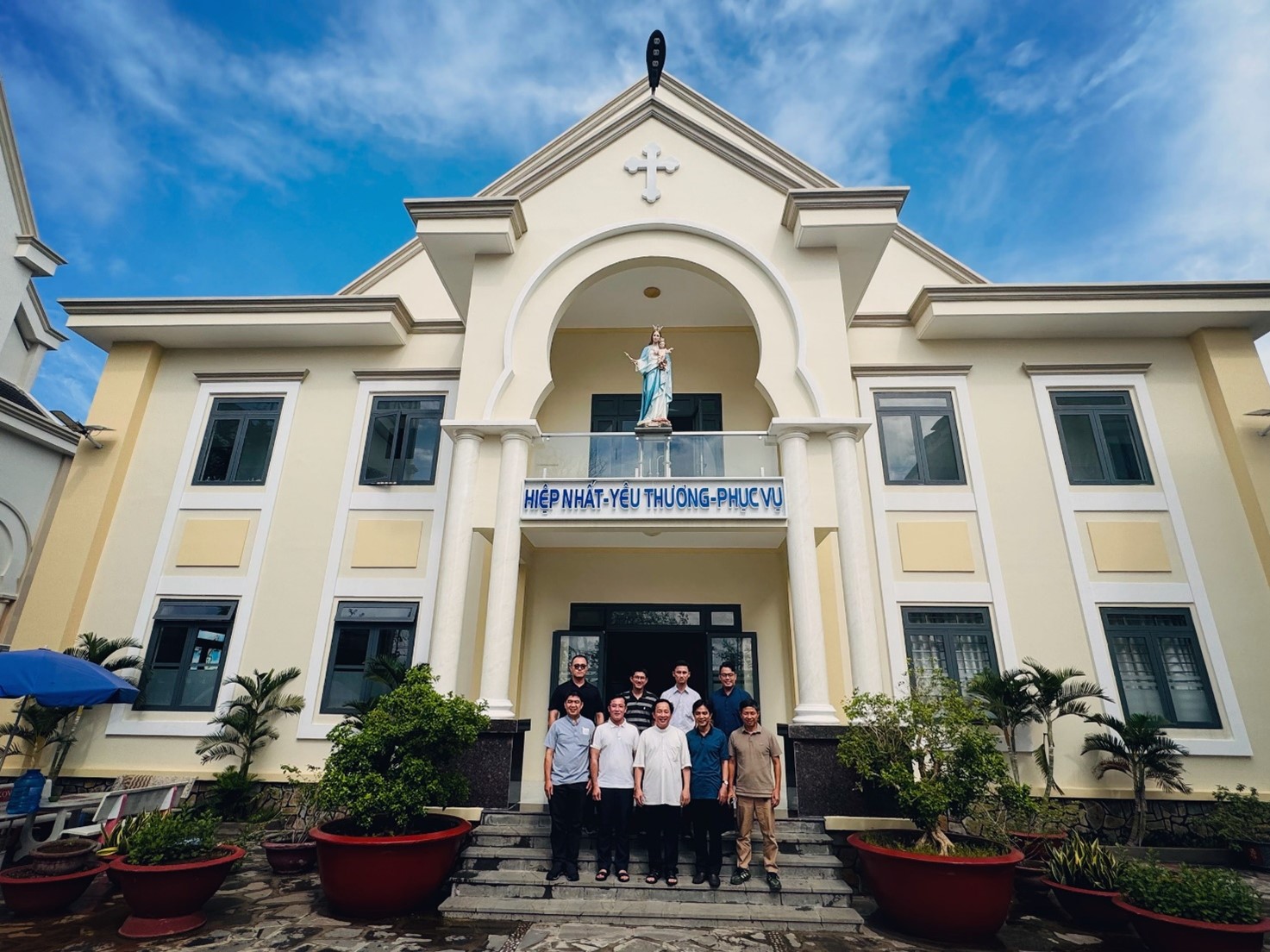 A group of people standing in front of a buildingDescription automatically generated