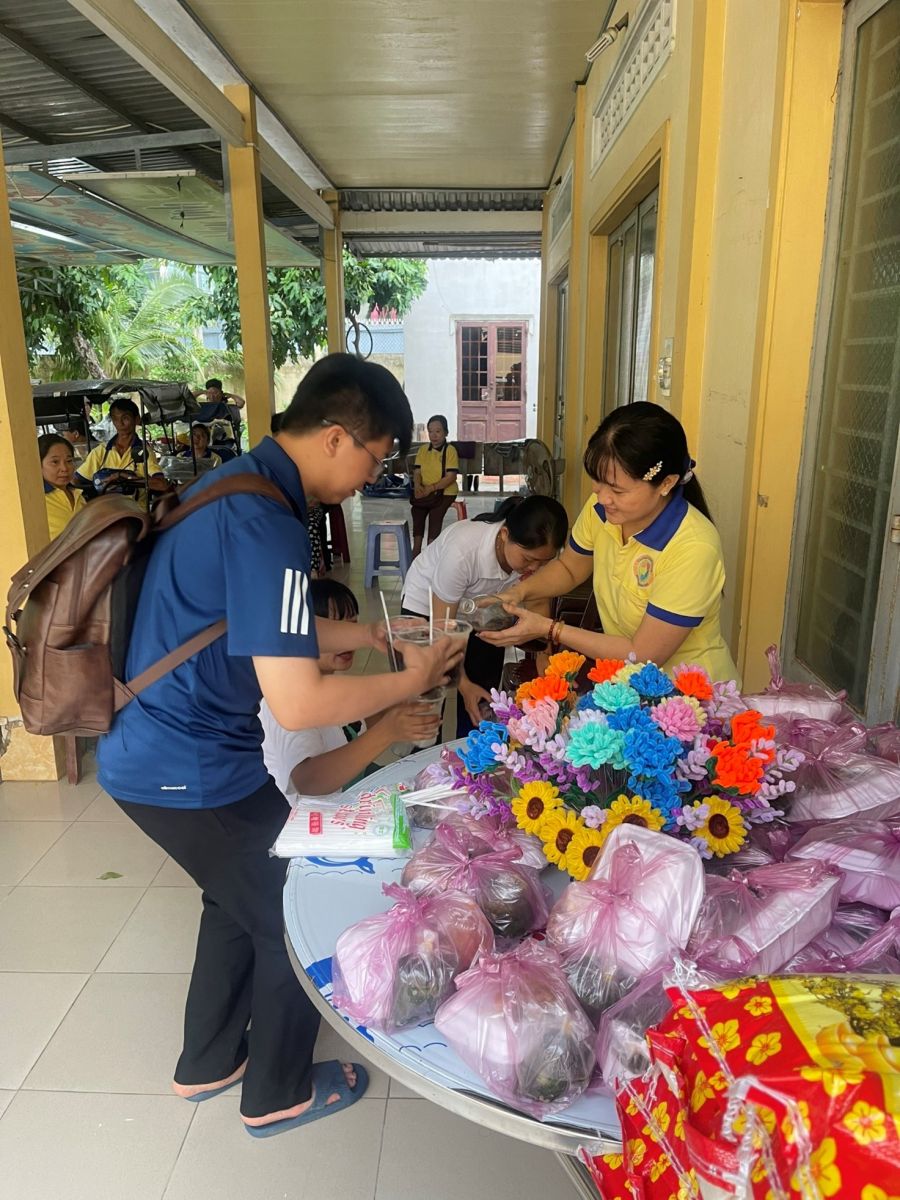 A group of people standing at a table with flowersDescription automatically generated